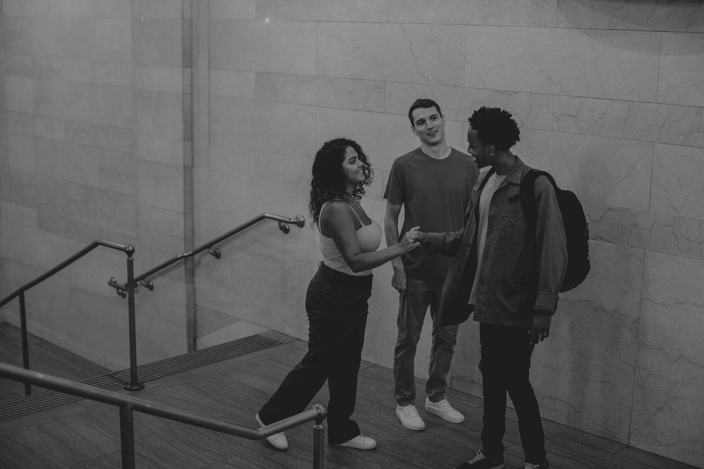 Cheerful multiracial friends communicating in hallway